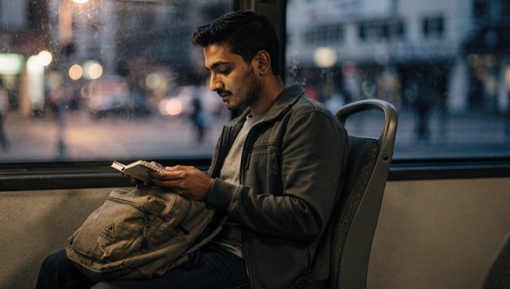 An adult learner studies notes on the bus ride home.
